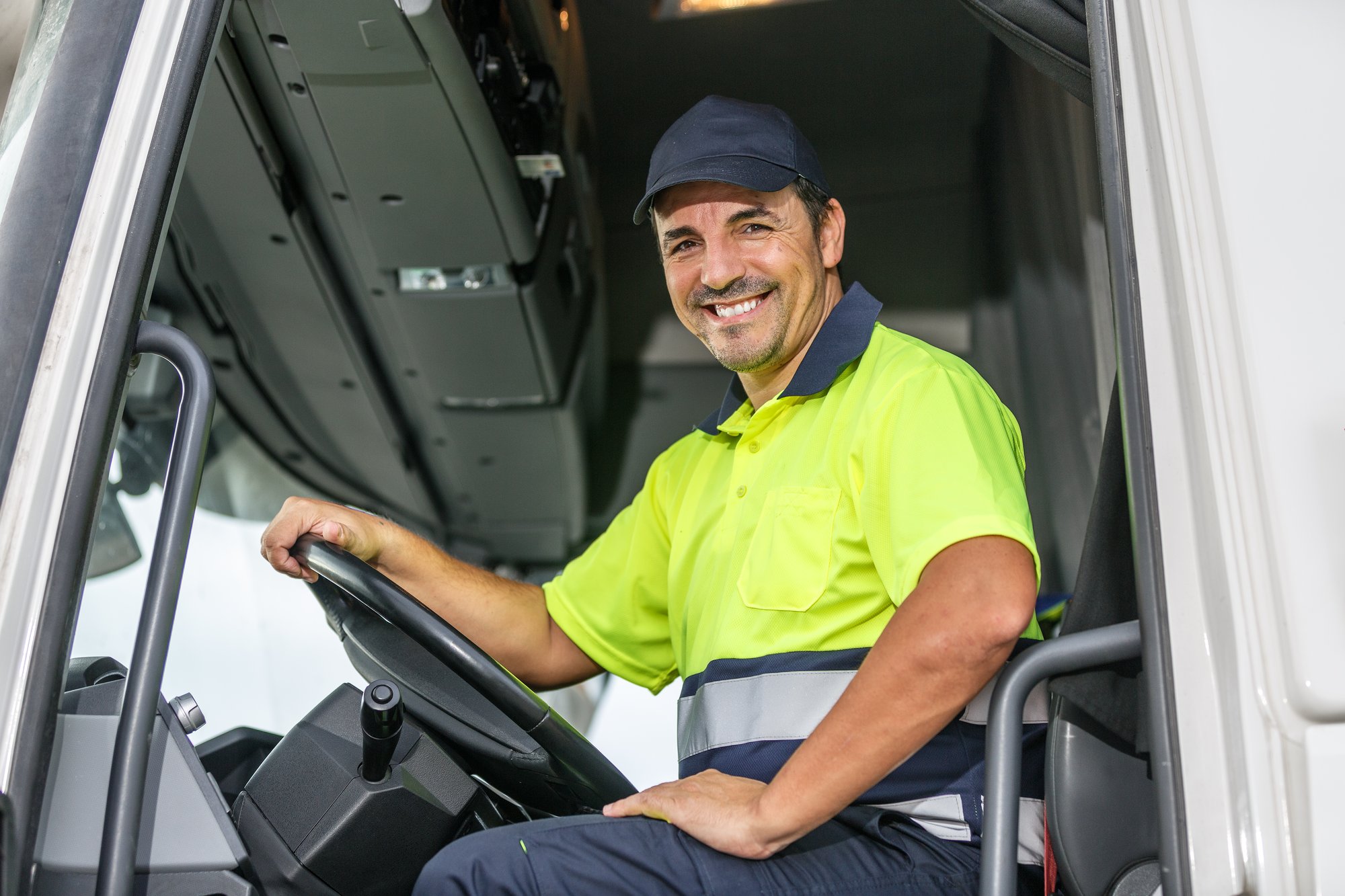 cheerful-male-driver-sitting-in-truck-while-lookin-2025-03-06-06-15-35-utc